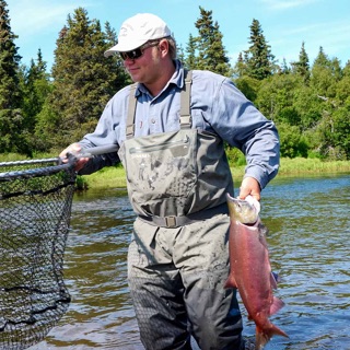 Dawson with a net and salmon at Legend Lodge