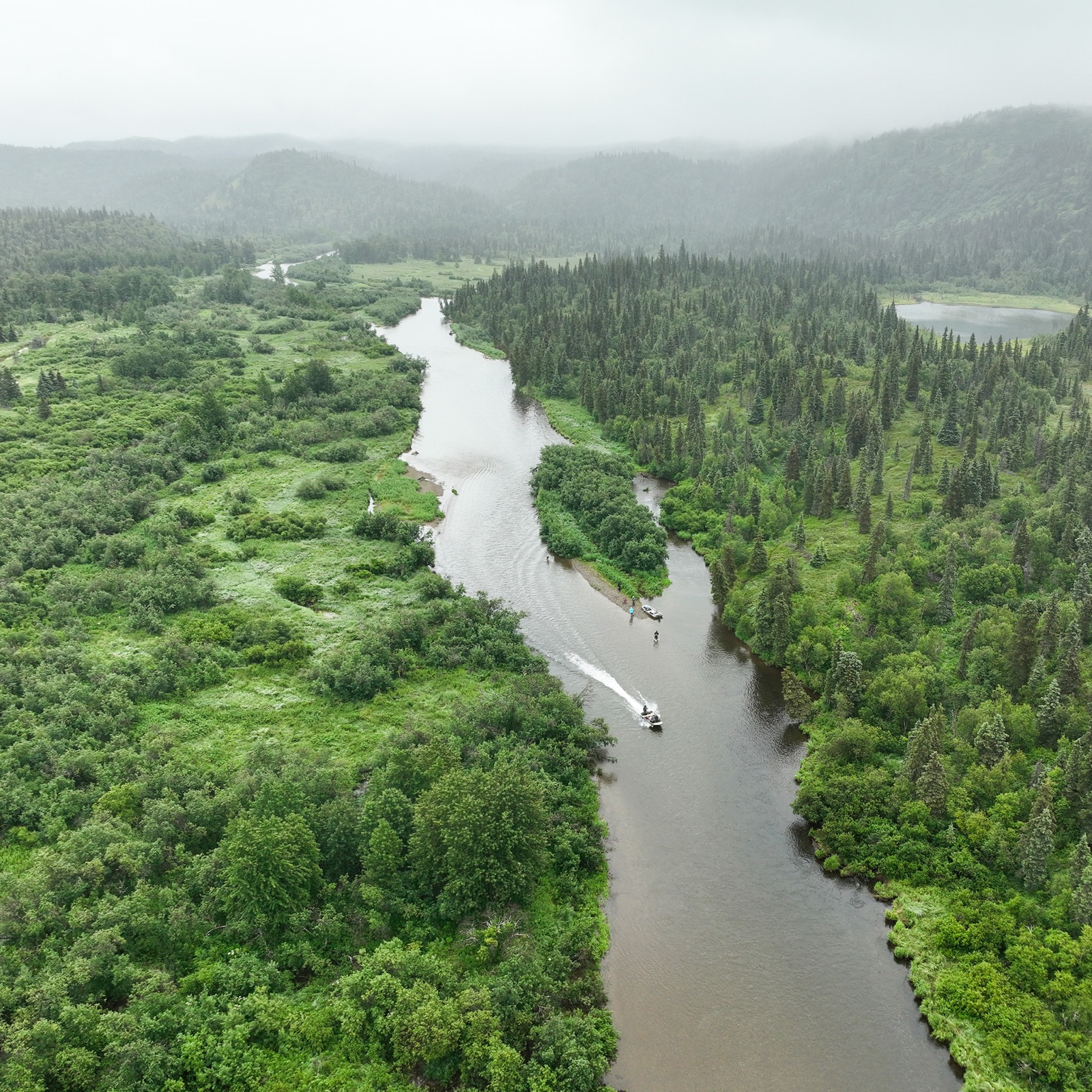 A guide boat running a winding river near Legend Lodge